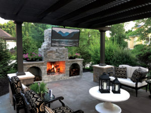 Picture of a beautiful porch with a pergola, an outdoor fireplace, and patio furniture.